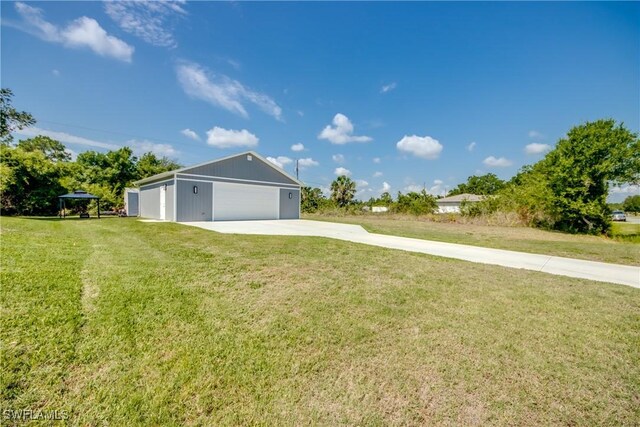 14160 Cedardale St, Fort Myers, FL 33905 - view of grassy yard featuring an outbuilding, driveway, and a detached garage