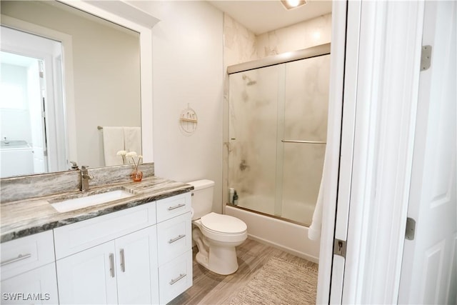 12083 Maiden Ln, Bonita Springs, FL 34135 - bathroom featuring vanity, toilet, bath / shower combo with glass door, and wood finished floors