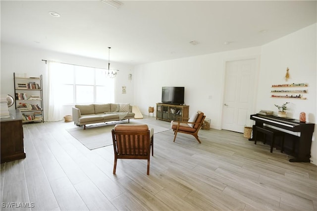 12083 Maiden Ln, Bonita Springs, FL 34135 - living room featuring a chandelier and light wood-style floors