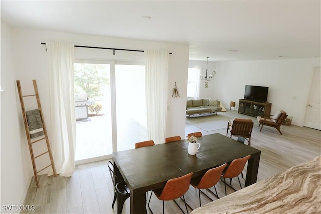 12083 Maiden Ln, Bonita Springs, FL 34135 - dining area featuring plenty of natural light, light wood-style flooring, and a chandelier