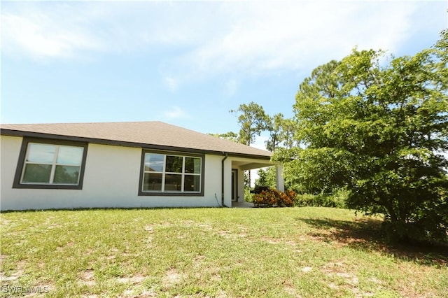 12083 Maiden Ln, Bonita Springs, FL 34135 - rear view of property featuring stucco siding and a yard