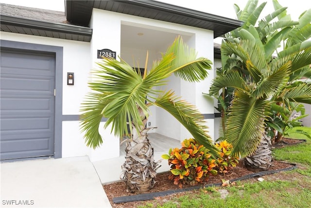 12083 Maiden Ln, Bonita Springs, FL 34135 - property entrance featuring stucco siding and a garage