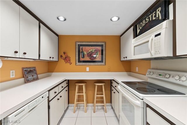 1036 S Collier Blvd Unit A103, Marco Island, FL 34145 - kitchen with white appliances, white cabinets, light countertops, recessed lighting, and light tile patterned floors