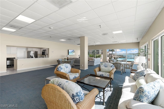 1036 S Collier Blvd Unit A103, Marco Island, FL 34145 - living room featuring light colored carpet, baseboards, and a drop ceiling