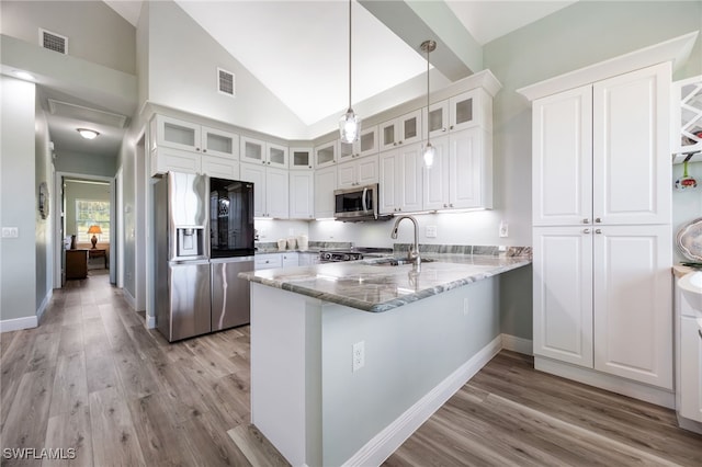 910 Gen George Patton Ave, Labelle, FL 33935 - kitchen featuring stainless steel appliances, a sink, a peninsula, light wood-style flooring, and white cabinets