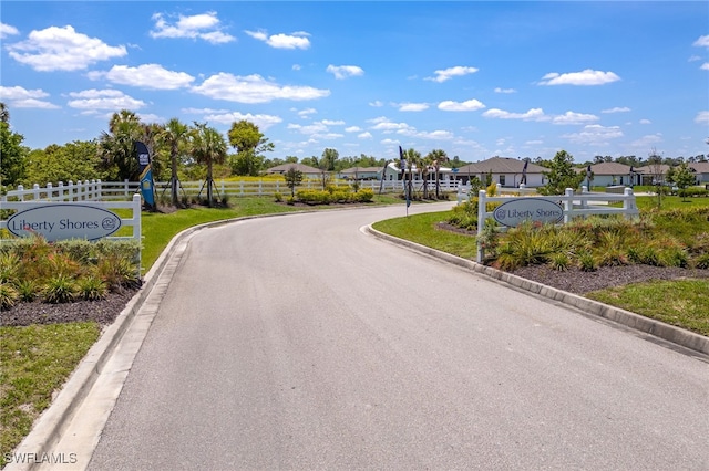 910 Gen George Patton Ave, Labelle, FL 33935 - view of asphalt street with curbs, a residential view, and street lights