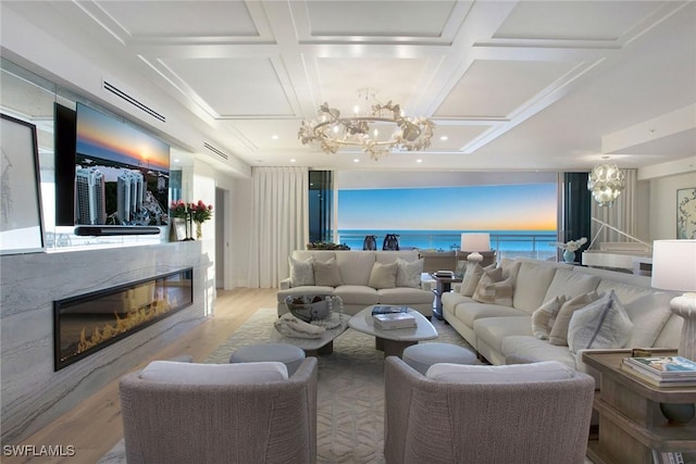13945 Old Coast Rd Unit 2204, Naples, FL 34110 - living room with a chandelier, a glass covered fireplace, wood finished floors, and coffered ceiling