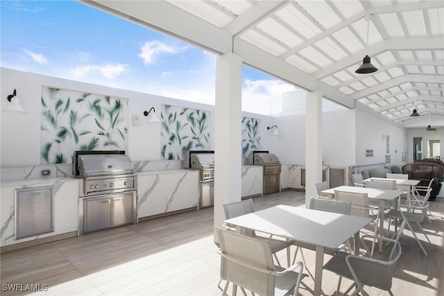 13945 Old Coast Rd Unit 2204, Naples, FL 34110 - view of patio / terrace with outdoor dining space, an outdoor kitchen, ceiling fan, and a deck