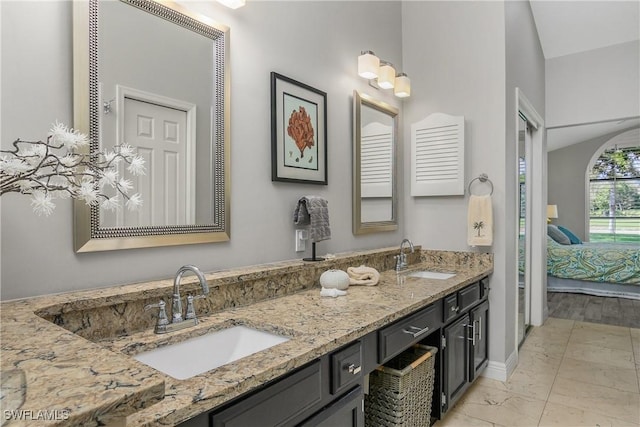 28908 Marsh Elder Ct, Bonita Springs, FL 34135 - ensuite bathroom with marble look tiles, double vanity, and baseboards
