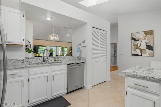 28908 Marsh Elder Ct, Bonita Springs, FL 34135 - kitchen with dishwasher, a sink, white cabinets, a skylight, and light tile patterned flooring