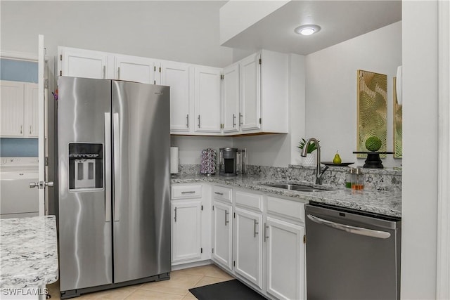 28908 Marsh Elder Ct, Bonita Springs, FL 34135 - kitchen with stainless steel appliances, a sink, washer / clothes dryer, and white cabinetry