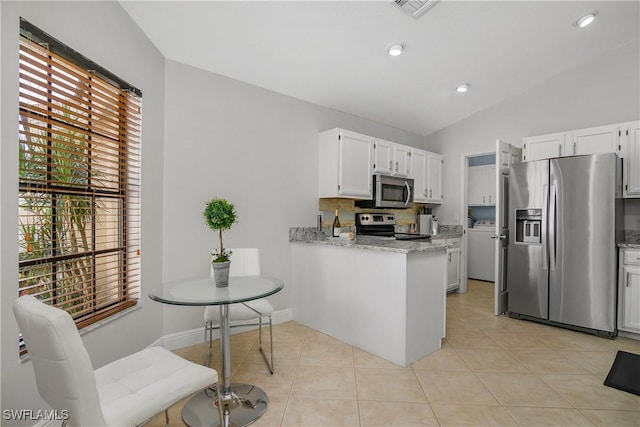 28908 Marsh Elder Ct, Bonita Springs, FL 34135 - kitchen with appliances with stainless steel finishes, lofted ceiling, white cabinets, a peninsula, and light stone counters