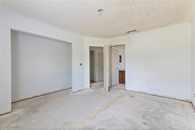 8172 Sanibel Blvd, Fort Myers, FL 33967 - unfurnished bedroom featuring unfinished concrete flooring, a closet, and a textured ceiling