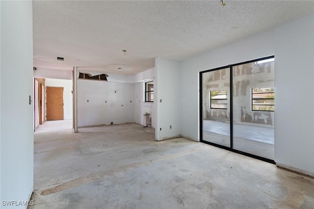 8172 Sanibel Blvd, Fort Myers, FL 33967 - empty room featuring concrete flooring and a textured ceiling