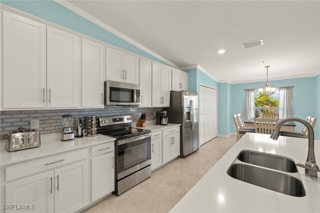 15960 Grassland Ln Unit 2726, Punta Gorda, FL 33982 - kitchen with stainless steel appliances, a sink, ornamental molding, decorative backsplash, and light tile patterned floors