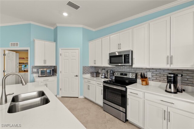 15960 Grassland Ln Unit 2726, Punta Gorda, FL 33982 - kitchen featuring appliances with stainless steel finishes, a sink, white cabinets, tasteful backsplash, and light countertops