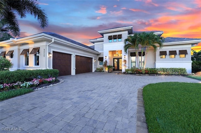 9010 Arrezo Ct, Naples, FL 34119 - view of front of house with decorative driveway, an attached garage, and stucco siding