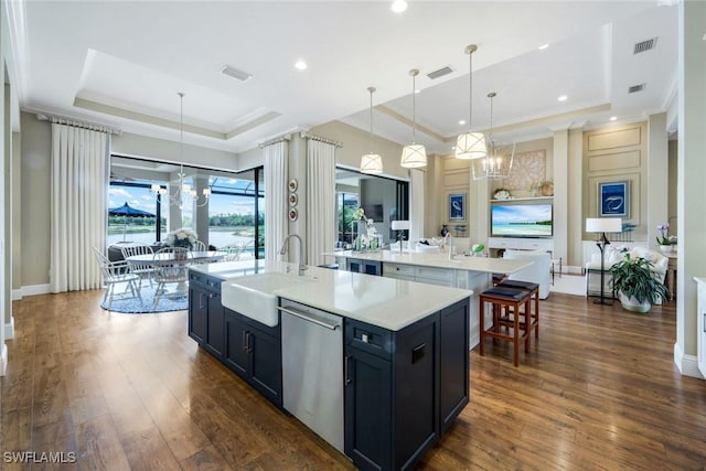 9010 Arrezo Ct, Naples, FL 34119 - kitchen featuring a raised ceiling, stainless steel dishwasher, a center island with sink, light countertops, and a chandelier