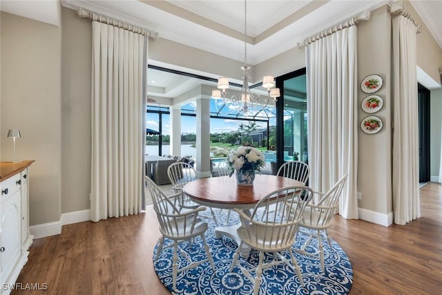 9010 Arrezo Ct, Naples, FL 34119 - dining room with wood finished floors, a chandelier, ornamental molding, and a tray ceiling