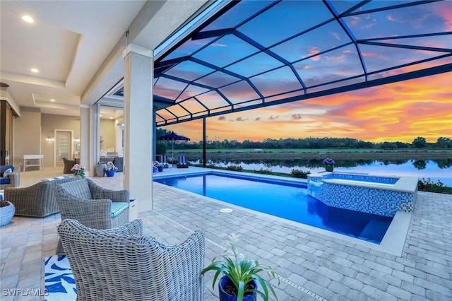 9010 Arrezo Ct, Naples, FL 34119 - pool at dusk with a water view, a patio, a pool with connected hot tub, and a lanai