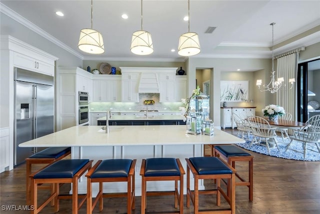9010 Arrezo Ct, Naples, FL 34119 - kitchen featuring stainless steel built in refrigerator, custom exhaust hood, tasteful backsplash, light countertops, and white cabinets