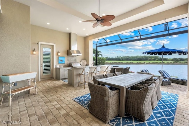 9010 Arrezo Ct, Naples, FL 34119 - view of patio / terrace featuring a water view, an outdoor kitchen, ceiling fan, a lanai, and outdoor dining area