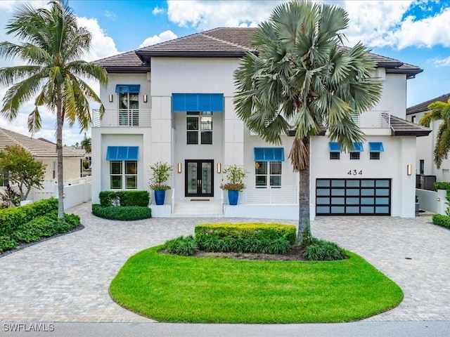 434 Conners Ave, Naples, FL 34108 - view of front of house with french doors, decorative driveway, stucco siding, an attached garage, and a tiled roof