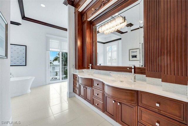 434 Conners Ave, Naples, FL 34108 - bathroom with ornamental molding, double vanity, a freestanding tub, decorative backsplash, and tile patterned flooring