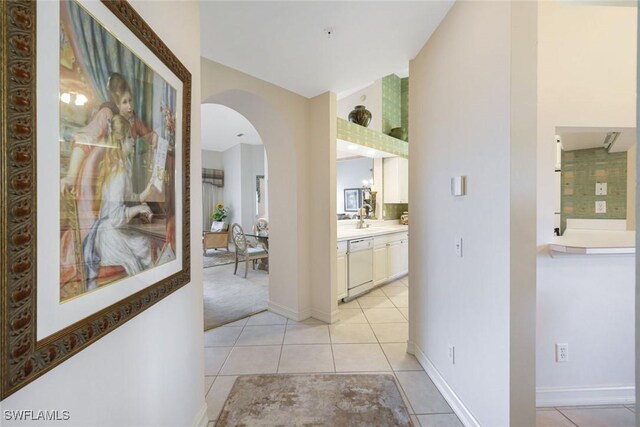 795 Bentwater Cir Unit 202, Naples, FL 34108 - corridor featuring arched walkways, light tile patterned flooring, baseboards, and lofted ceiling