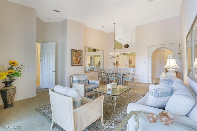 795 Bentwater Cir Unit 202, Naples, FL 34108 - living area featuring carpet flooring, a high ceiling, arched walkways, a chandelier, and baseboards