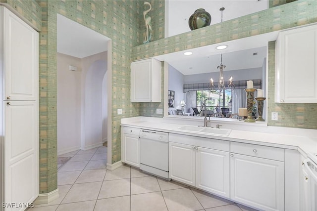 795 Bentwater Cir Unit 202, Naples, FL 34108 - kitchen featuring white dishwasher, a sink, arched walkways, white cabinets, and a high ceiling