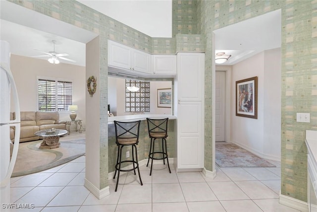 795 Bentwater Cir Unit 202, Naples, FL 34108 - kitchen featuring light tile patterned floors, baseboards, white cabinets, freestanding refrigerator, and ceiling fan