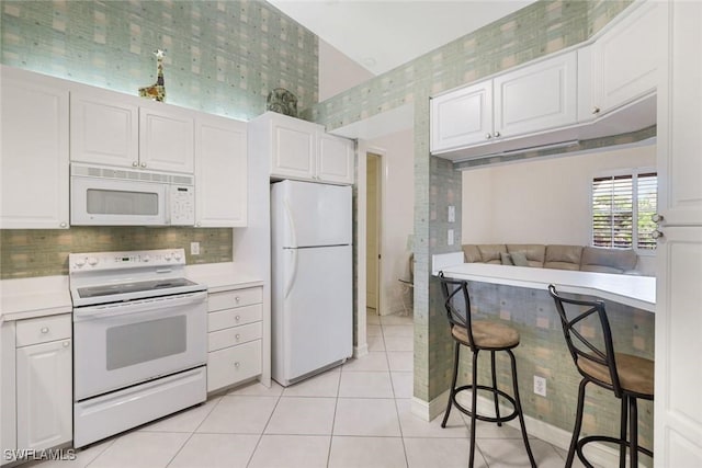 795 Bentwater Cir Unit 202, Naples, FL 34108 - kitchen with white appliances, light tile patterned floors, light countertops, and white cabinetry