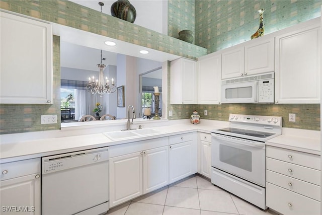 795 Bentwater Cir Unit 202, Naples, FL 34108 - kitchen with white appliances, a sink, a chandelier, and light countertops