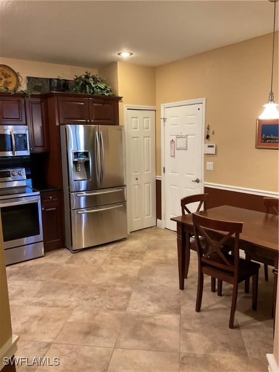 17560 Brickstone Loop, Fort Myers, FL 33967 - kitchen with stainless steel appliances, dark brown cabinetry, and hanging light fixtures