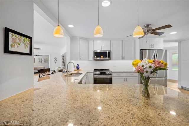 636 Park Shore Dr, Naples, FL 34103 - kitchen with stainless steel appliances, light stone counters, white cabinetry, a ceiling fan, and recessed lighting
