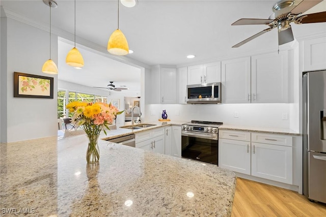636 Park Shore Dr, Naples, FL 34103 - kitchen with stainless steel appliances, ceiling fan, white cabinetry, light stone countertops, and pendant lighting