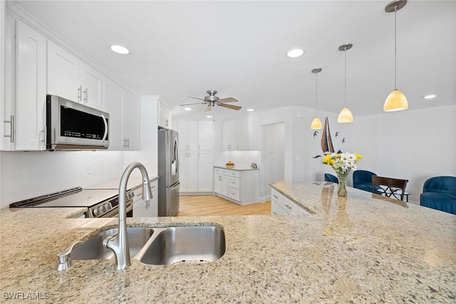 636 Park Shore Dr, Naples, FL 34103 - kitchen with appliances with stainless steel finishes, light stone counters, a ceiling fan, white cabinets, and recessed lighting