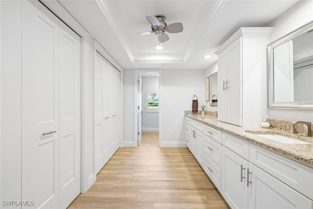 636 Park Shore Dr, Naples, FL 34103 - bathroom featuring a tray ceiling, double vanity, wood finished floors, ceiling fan, and recessed lighting