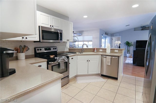1129 NW 19th Ave, Cape Coral, FL 33993 - kitchen with stainless steel appliances, a peninsula, a sink, backsplash, and lofted ceiling