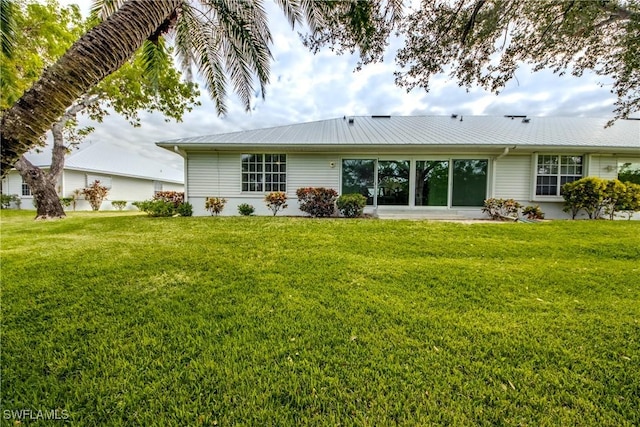 15371 River Vista Dr Unit 803, North Fort Myers, FL 33917 - back of house with a yard and metal roof