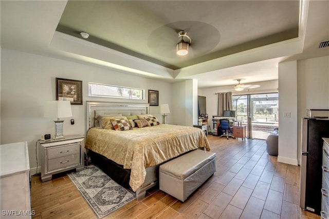 141 SW 39th St, Cape Coral, FL 33914 - bedroom featuring a raised ceiling, an office area, access to exterior, light wood-style flooring, and ceiling fan