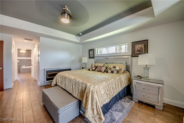 141 SW 39th St, Cape Coral, FL 33914 - bedroom with a raised ceiling, wood finished floors, baseboards, connected bathroom, and ceiling fan