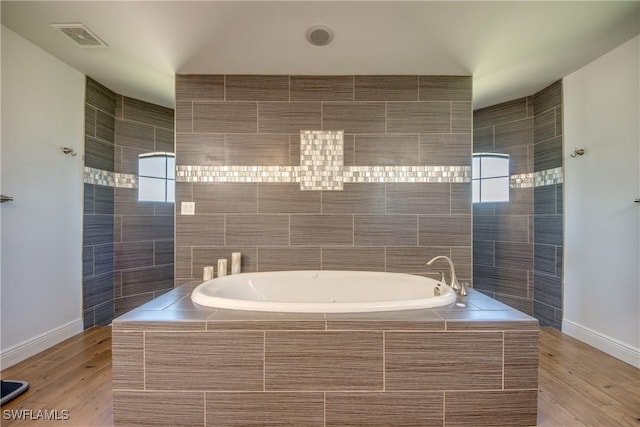 141 SW 39th St, Cape Coral, FL 33914 - bathroom featuring a bath, baseboards, and wood finished floors