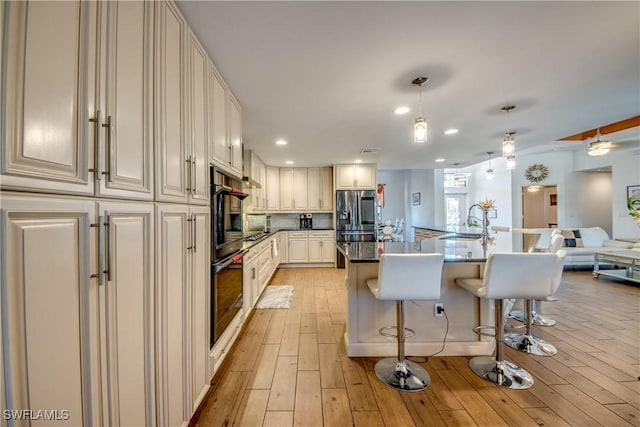141 SW 39th St, Cape Coral, FL 33914 - kitchen with appliances with stainless steel finishes, a kitchen breakfast bar, light wood-style flooring, recessed lighting, and open floor plan
