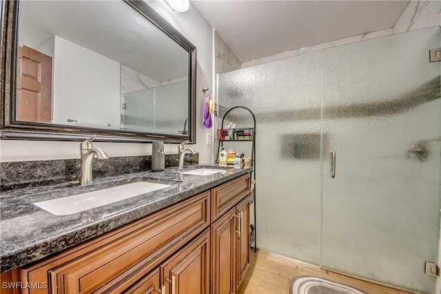 141 SW 39th St, Cape Coral, FL 33914 - bathroom with double vanity, a stall shower, and wood finished floors