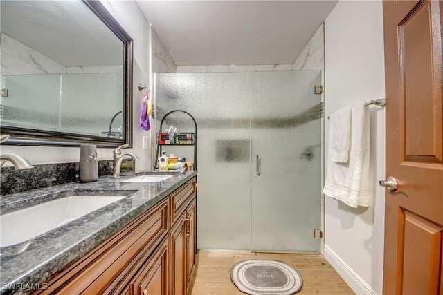 141 SW 39th St, Cape Coral, FL 33914 - bathroom with a stall shower, wood finished floors, and double vanity
