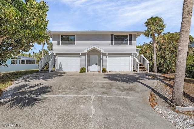 7836 Grande Pine Rd, Bokeelia, FL 33922 - view of front facade featuring stairway, an attached garage, and concrete driveway