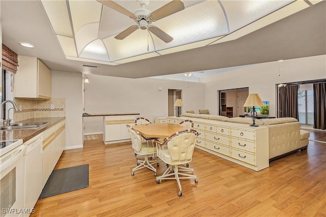7836 Grande Pine Rd, Bokeelia, FL 33922 - kitchen featuring a sink, a ceiling fan, open floor plan, a tray ceiling, and light wood finished floors