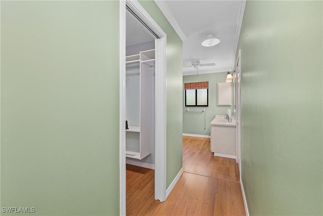 7836 Grande Pine Rd, Bokeelia, FL 33922 - hallway with light wood finished floors, baseboards, ornamental molding, and a sink